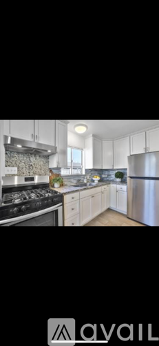 A modern kitchen with stainless steel appliances and white cabinets.