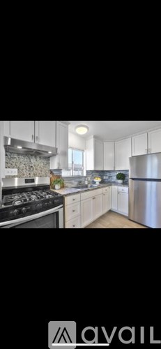 A modern kitchen with stainless steel appliances and white cabinets.