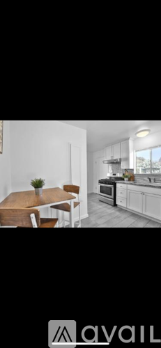A kitchen with white cabinets and a wooden table.