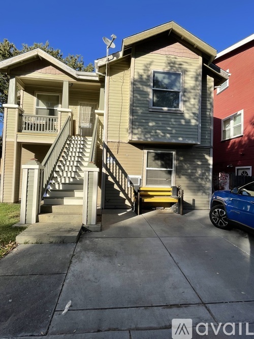 A two-story house with a car parked in front.