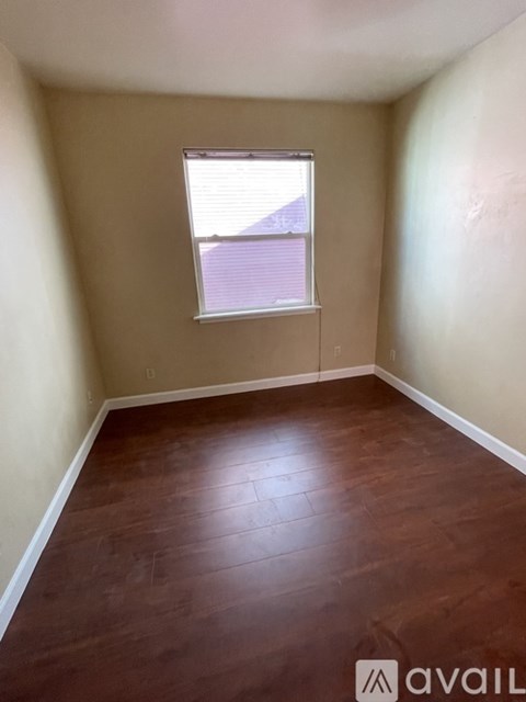 A room with wooden flooring and a window.