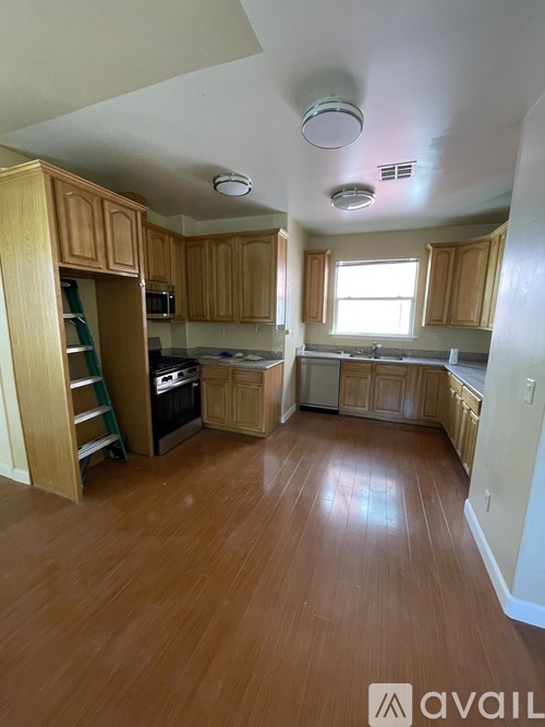 A kitchen with wooden cabinets and a wooden floor.