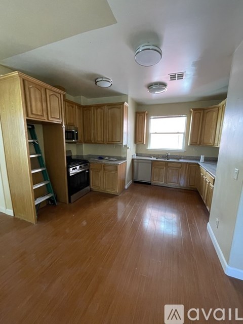 A kitchen with wooden cabinets and a wooden floor.