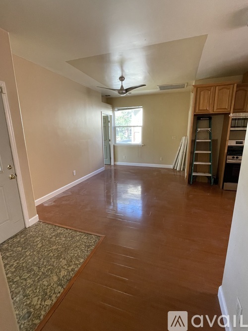 A room with wooden floors and a ceiling fan.