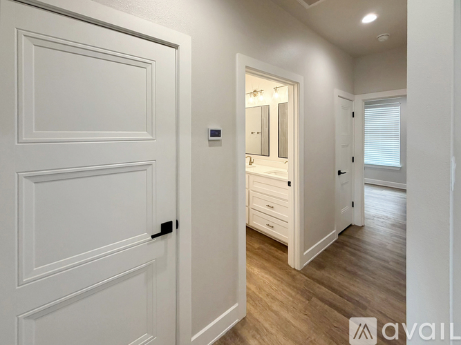 A white door with a black handle is on the left and a mirror is on the right.