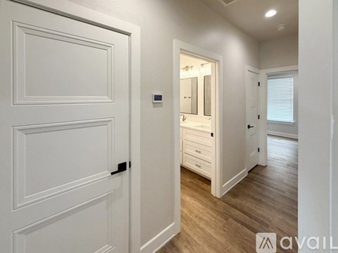 A white door with a black handle is on the left and a mirror is on the right.