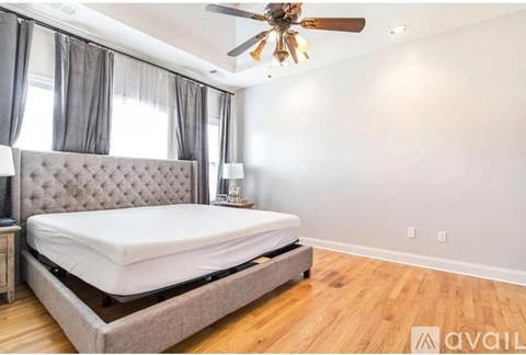 A bedroom with a large bed and a ceiling fan.