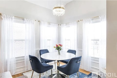 A dining room with a round table and chairs.