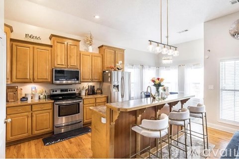 A kitchen with wooden cabinets and a black stove top oven.