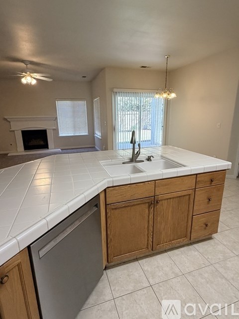 A kitchen with a white countertop and wooden cabinets.