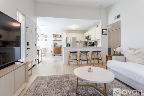 A living room with a white couch, a television, and a coffee table.