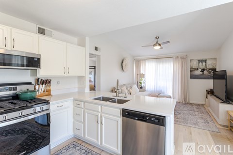 A kitchen with white cabinets and a black stove top.