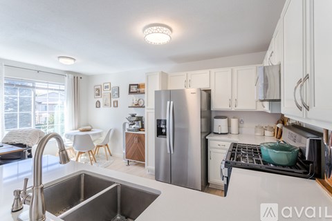 A kitchen with a sink, refrigerator, and oven.