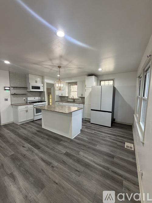 A kitchen with a large island and a refrigerator.