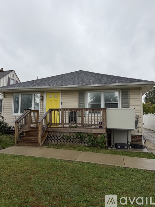 A house with a yellow door and a deck.