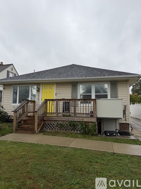 A house with a yellow door and a deck.