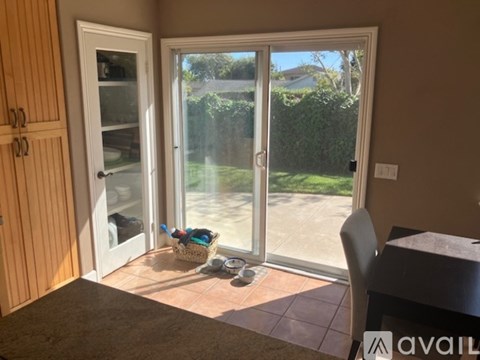 A room with a table and chairs and a basket on the floor.