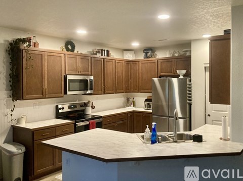 A kitchen with wooden cabinets and a stainless steel refrigerator.