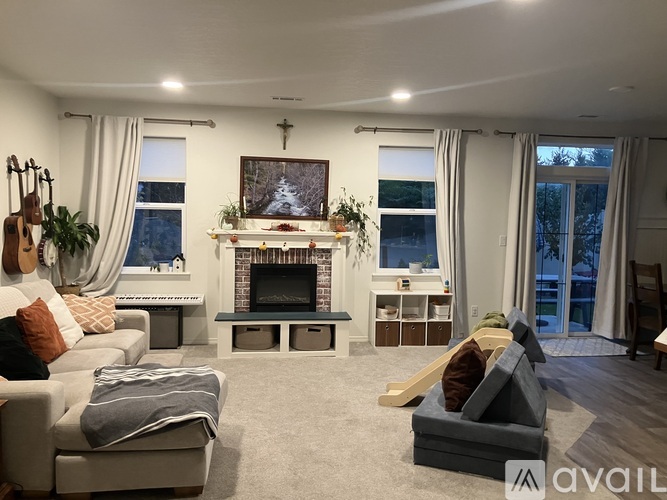 A living room with a fireplace and a painting above it.