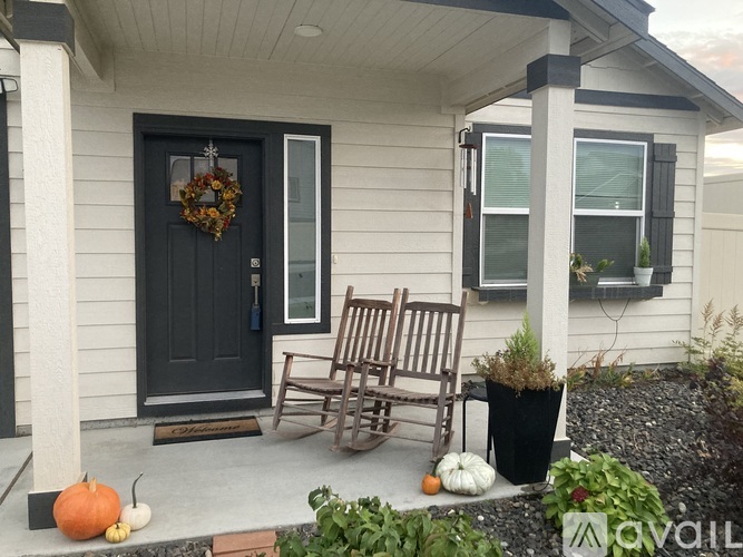 A house entrance with a black door and a wreath on it.