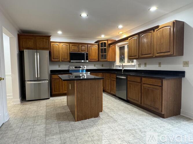 A kitchen with wooden cabinets and black countertops.