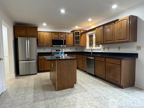 A kitchen with wooden cabinets and black countertops.