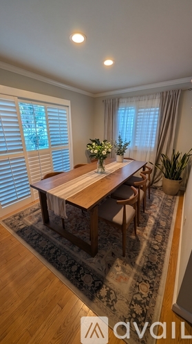 A dining room with a wooden table and chairs.