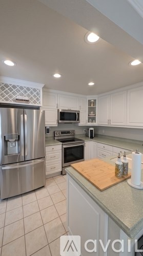 A kitchen with a stainless steel refrigerator, microwave, and oven.