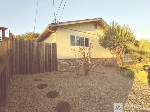 A house with a gravel driveway and a wooden fence.
