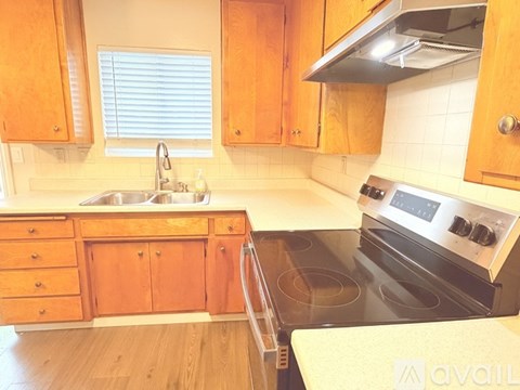 A kitchen with wooden cabinets and a stove top oven.