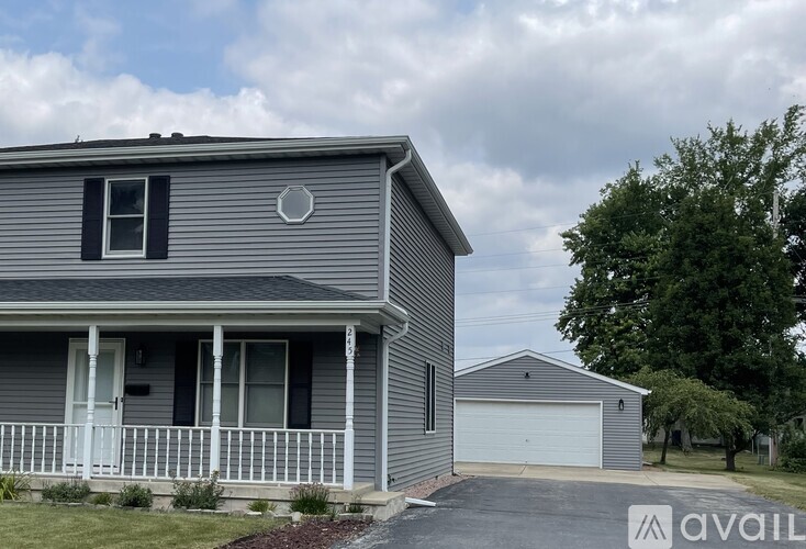 A house with a grey exterior and a white porch.