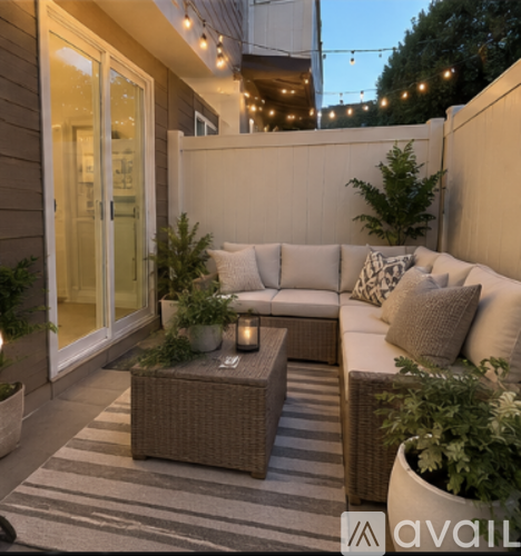 A patio with a white couch and a coffee table.