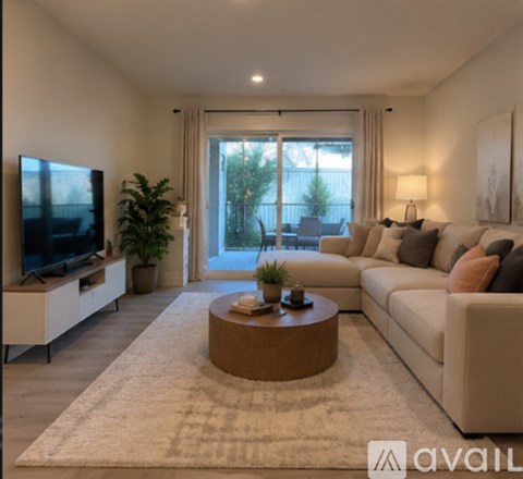 A living room with a flat screen TV, a sofa, and a coffee table.