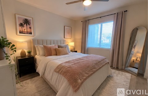 A bedroom with a large bed and a ceiling fan.