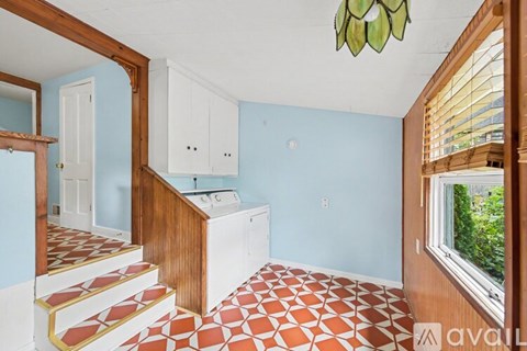A kitchen with a white dishwasher and a wooden cabinet.