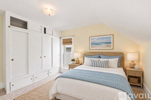 A bedroom with a large bed and a painting on the wall.