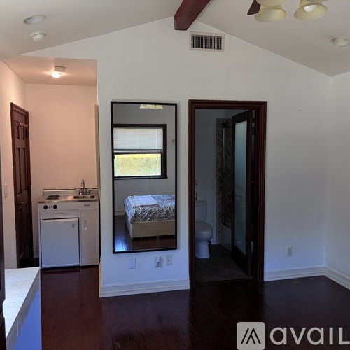 A bedroom with a mirror and a washer and dryer.