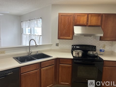 A kitchen with wooden cabinets and a black stove top oven.
