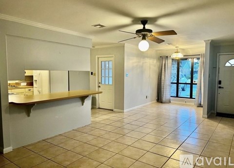 A spacious room with a ceiling fan and tiled flooring.