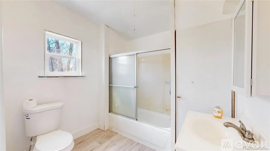 A white bathroom with a toilet, sink, and bathtub.