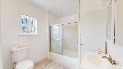 A white bathroom with a toilet, sink, and bathtub.