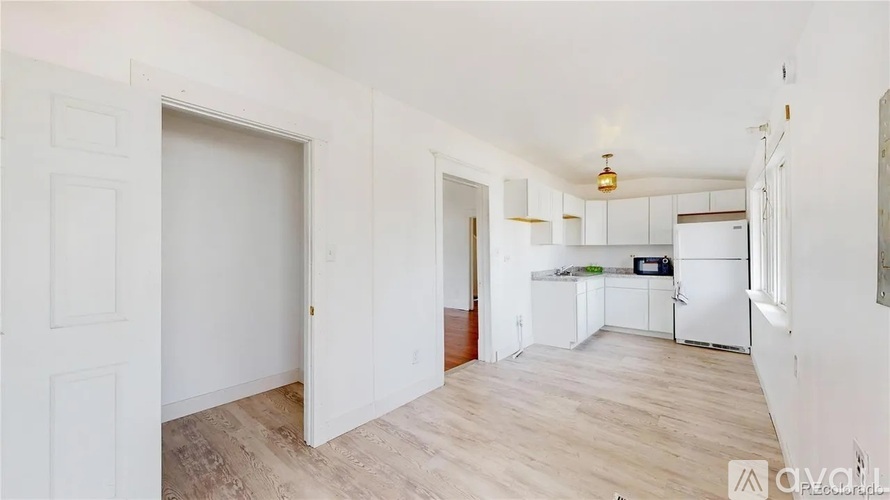 A kitchen area with white cabinets and a refrigerator.