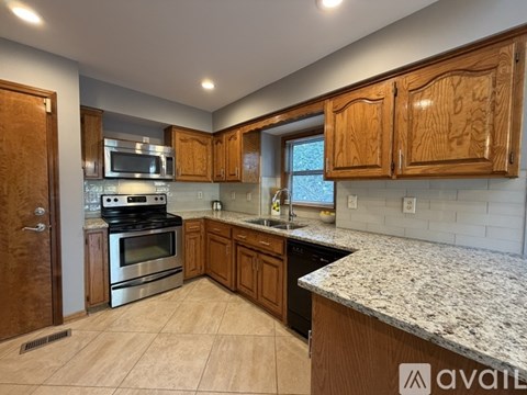 A kitchen with wooden cabinets and granite countertops.