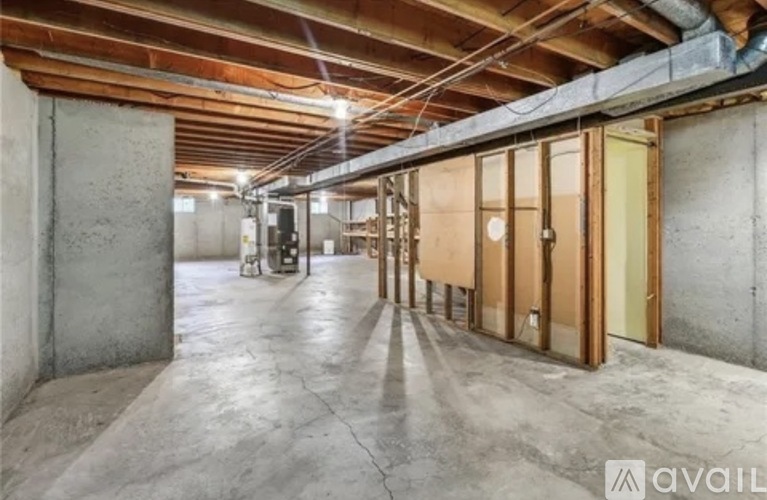 A spacious garage with wooden floors and exposed ceiling beams.