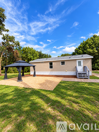 A house with a covered patio and a well-kept lawn.