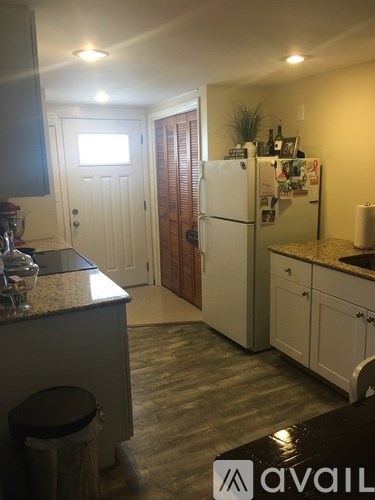 A kitchen with a white fridge and cabinets.