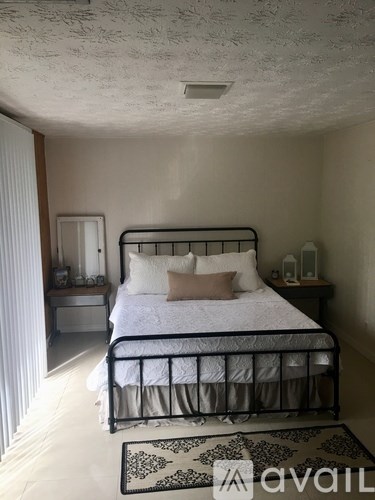 A bedroom with a bed, nightstand, and lamp.