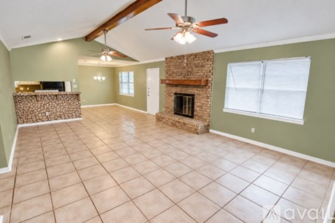 A living room with a fireplace and a ceiling fan.