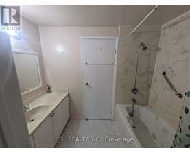 A bathroom with a white door and a shower with a glass door.