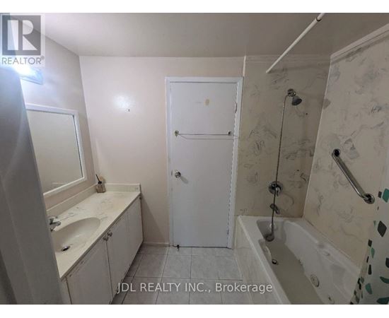 A bathroom with a white door and a shower with a glass door.